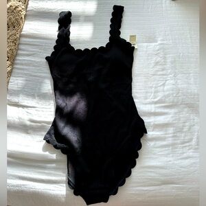 Black scalloped one piece bathing suit. Never worn nor tried on, still has tags